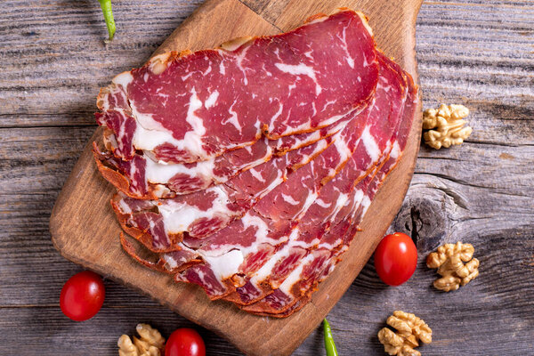 Turkish pastrami. Bacon made from ribeye meat. Beef pastrami sliced Pastirma or Turkish pastrami. Close-up.