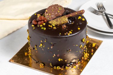 Çam fıstıklı çikolatalı kek. Beyaz arka planda kutlama ya da doğum günü pastası. Kapat.