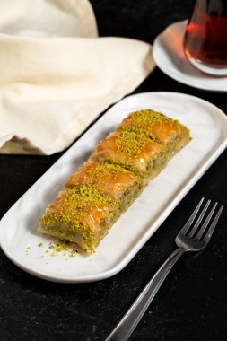 Fıstıklı baklava. Siyah arka planda fıstıklı Baklava. Geleneksel Akdeniz mutfağı aroması. Kapat.