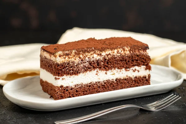 Tiramisu keki. Koyu arkaplanda katmanlı tiramisu keki. Kapat.