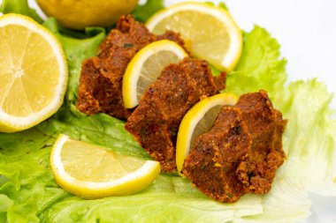 Beyaz arka planda çiğ köfte ya da puro. Yakın plan. yerel isim cig kofte
