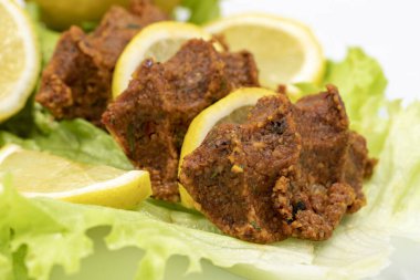 Beyaz arka planda çiğ köfte ya da puro. Yakın plan. yerel isim cig kofte