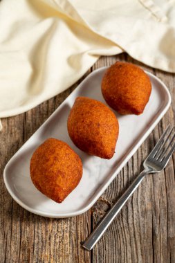 Ahşap bir arka planda Kibbeh. Geleneksel Türk mutfağı lezzetleri. Yakın plan. yerel adı icli kofte