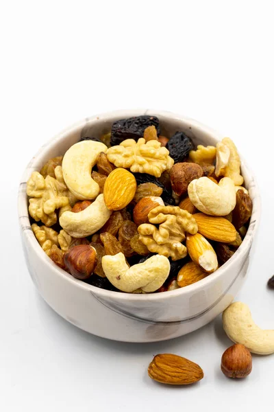 Mixed nuts on white background. Nuts, walnuts, raisins and cashews. close up