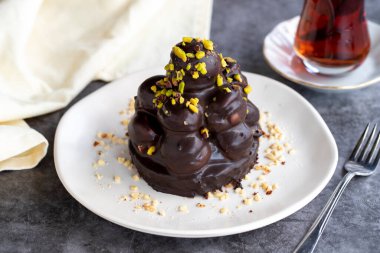 Profiterol keki. Hamur işi ürünü. Koyu arkaplanda profiterol keki. Yakın plan.