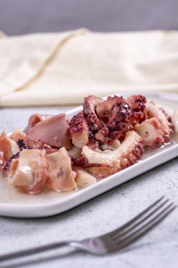 Ahtapot salatası. Akdeniz mutfağı lezzetlidir. Taş zemin üzerinde zeytinyağı olan ahtapot kolları. Yakın plan.