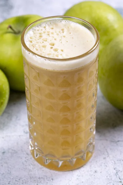 Apple juice. Freshly squeezed juice. Freshly squeezed apple juice in glass on stone background. Close-up