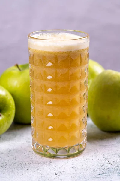 Apple juice. Freshly squeezed juice. Freshly squeezed apple juice in glass on stone background. Close-up