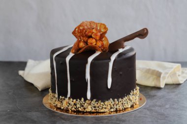 Çikolatalı ve croquant keki. Karanlık bir arkaplanda kutlama pastası. Kapat.