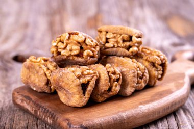 Kurutulmuş incir dolması. Ahşap zeminde cevizle doldurulmuş kuru incirler. Yakın plan. yerel adı cevizli incir