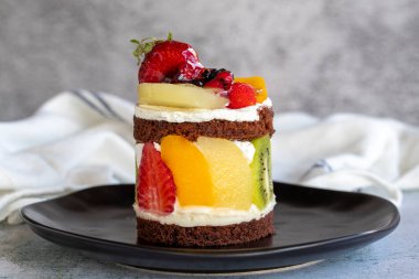 Meyveli kek. Taş zeminde meyvelerle çevrili bir pasta. Pastane ürünleri. Yakın plan..