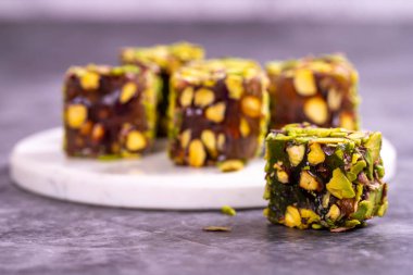 Fıstıklı Türk Lokumu koyu bir arka planda. Geleneksel Türk lezzetleri. Elma aromalı Türk Lokumu. Kapat.