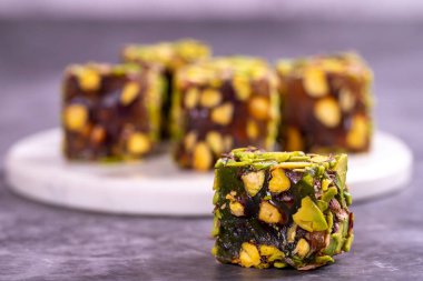 Fıstıklı Türk Lokumu koyu bir arka planda. Geleneksel Türk lezzetleri. Elma aromalı Türk Lokumu. Kapat.