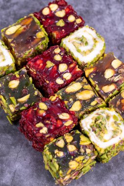 Karanlık arka planda Türk zevki. Geleneksel Türk lezzetleri. Fıstıklı Türk Lokumu çeşitleri. Kapat.