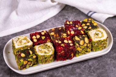 Karanlık arka planda Türk zevki. Geleneksel Türk lezzetleri. Fıstıklı Türk Lokumu çeşitleri. Kapat.