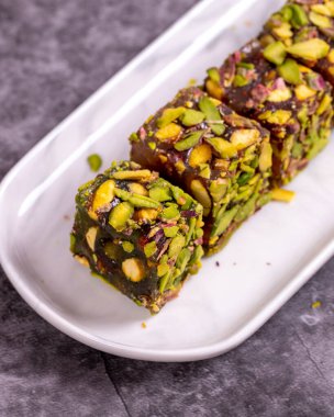 Fıstıklı Türk Lokumu koyu bir arka planda. Geleneksel Türk lezzetleri. Elma aromalı Türk Lokumu. Kapat.