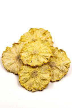 Kurutulmuş ananas dilimleri. Beyaz arka planda izole edilmiş dilimlenmiş kuru ananas. Kurutulmuş meyve. Kapat.
