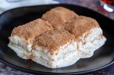 Soğuk baklava. Renkli arka planda süt olan baklava. Türk mutfağı lezzetleri. Kapat.