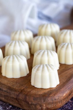 Beyaz çikolata. Özel midye görünümlü çikolata. Renkli arka planda özel çikolata. Kapat.