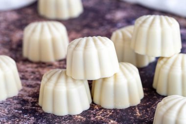 Beyaz çikolata. Özel midye görünümlü çikolata. Renkli arka planda özel çikolata. Kapat.