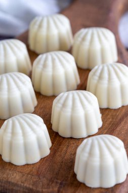 Beyaz çikolata. Özel midye görünümlü çikolata. Renkli arka planda özel çikolata. Kapat.