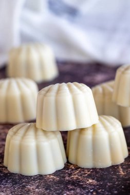 Beyaz çikolata. Özel midye görünümlü çikolata. Renkli arka planda özel çikolata. Kapat.