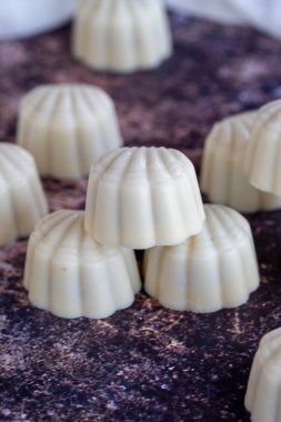 Beyaz çikolata. Özel midye görünümlü çikolata. Renkli arka planda özel çikolata. Kapat.