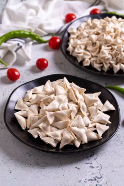 Taş zeminde donmuş ravioli. Ortada doldurulmuş ravioli. Türk mantısı. Geleneksel dünya mutfağı lezzetleri. Yakın plan..