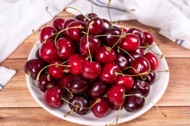 Taze kiraz. Ahşap arka planda olgun kirazlar. Toplu kiraz. Kapat.