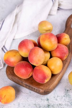 Taze kayısılar. Taş zeminde servis tabağı içinde olgun kayısılar. Toplu kayısılar. Kapat.