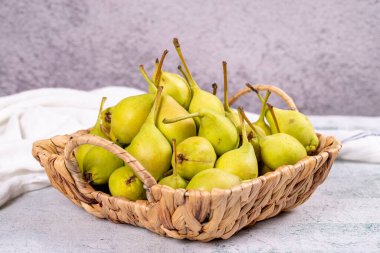 Taze armut. Taş bir arka planda sepetteki olgun armutlar. Toplu armut. Kapat.