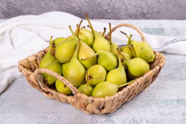 Taze armut. Taş bir arka planda sepetteki olgun armutlar. Toplu armut. Kapat.