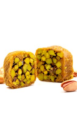 Fıstıklı kadayif. Kadayif baklava beyaz arkaplanda izole edildi. Geleneksel Türk mutfağı lezzetleri. Kadayif tatlısının ortasında şam fıstığı var. Kapat.