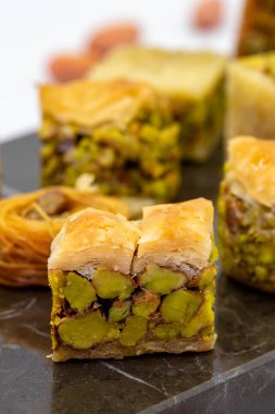 Varieties of pistachio baklava. Variety of baklava isolated on white background. Traditional Turkish cuisine delicacies. Desserts with pistachio syrup in the middle. close up