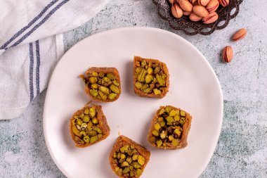 Fıstıklı kadayif tatlısı. Taş zeminde şam fıstıklı Kadayif baklavası. Türk mutfağı tatlısı. Yakın plan. yerel adı Fistikli kadayif