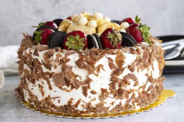 Meyveli kek. Taş zeminde beyaz çikolata ve meyveli pasta. Kutlama ve doğum günü pastası. Kapat.