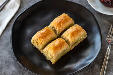 Türk baklavası. Baklava, arka planda şam fıstıklı dilimler. Fırın ürünleri. Yan görünüş. Türk mutfağı. Yakın plan..