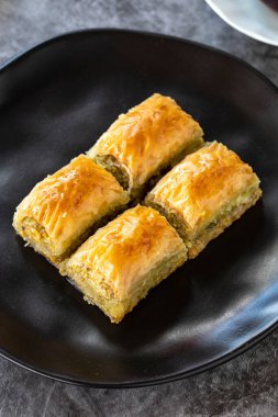 Türk baklavası. Baklava, arka planda şam fıstıklı dilimler. Fırın ürünleri. Dikey görünüm. Türk mutfağı. Yakın plan..