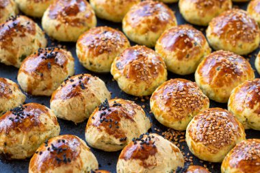 Susamlı kurabiye. Koyu arkaplanda taze tuzlu kurabiye. Fırın ürünleri. Yan görünüş. Yakın plan..