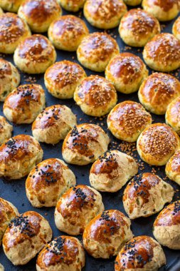 Susamlı kurabiye. Koyu arkaplanda taze tuzlu kurabiye. Fırın ürünleri. Dikey görünüm. Yakın plan..