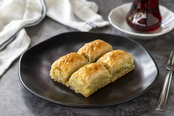 Turkish baklava. Baklava slices with pistachio on a dark background. Bakery products. side view. Turkish cuisine. Close-up.