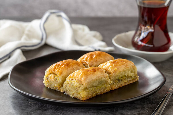 Turkish baklava. Baklava slices with pistachio on a dark background. Bakery products. side view. Turkish cuisine. Close-up.