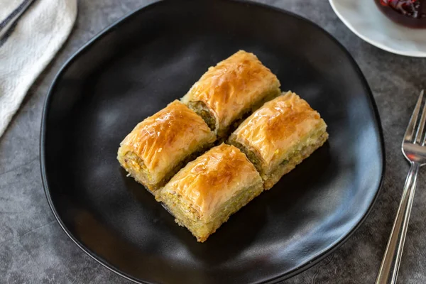 Türk baklavası. Baklava, arka planda şam fıstıklı dilimler. Fırın ürünleri. Yan görünüş. Türk mutfağı. Yakın plan..