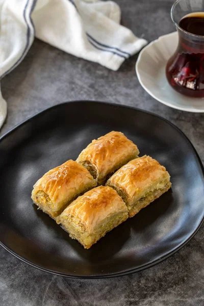 Türk baklavası. Baklava, arka planda şam fıstıklı dilimler. Fırın ürünleri. Dikey görünüm. Türk mutfağı. Yakın plan..