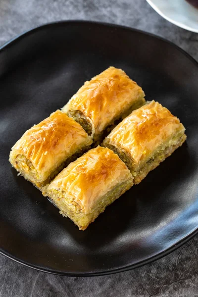 Türk baklavası. Baklava, arka planda şam fıstıklı dilimler. Fırın ürünleri. Dikey görünüm. Türk mutfağı. Yakın plan..