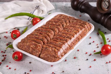 Paketlenmemiş baharatlı ızgara köfte. Taş zeminde köfteler. Kapat.