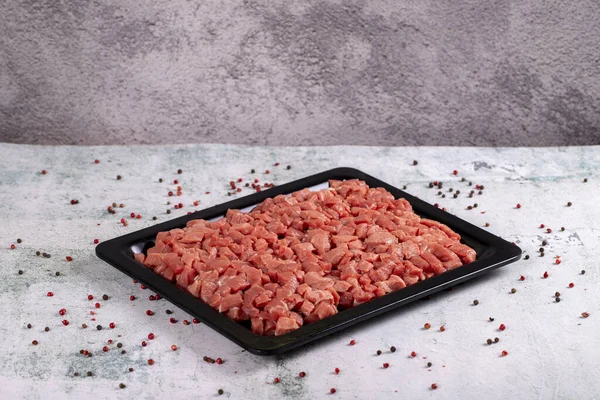 Cubed meat. Chopped red meat on stone background. Butcher products