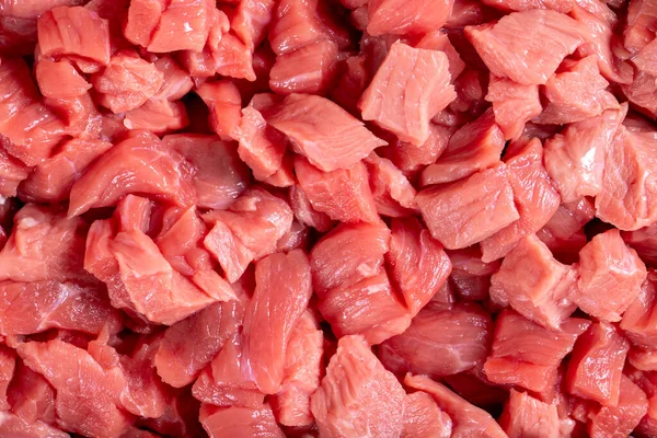 Cubed meat. Chopped red meat on stone background. Butcher products. Close up