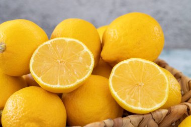 Fresh lemon. Organic lemons in a basket on a stone background. close up
