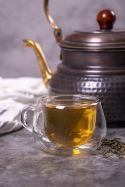 Green tea. Green tea brewed with copper teapot on dark background. Healthy drinks. Herbal tea concept. close up